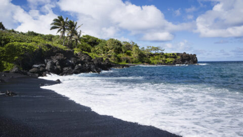 A view of the black sands and the ocean at Honokalani Beach