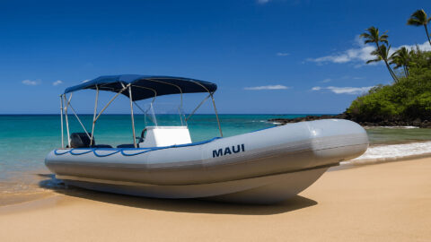 A boat used for rafting on a sandy beach in Maui