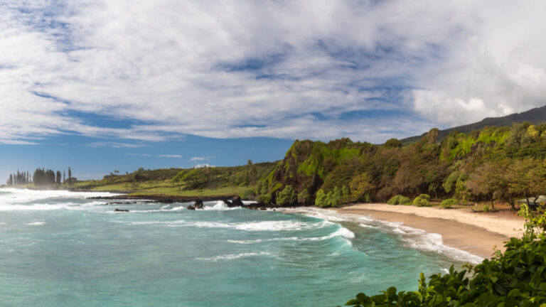 The golden crescent beach of Hamoa with turquoise water and lush backdrop