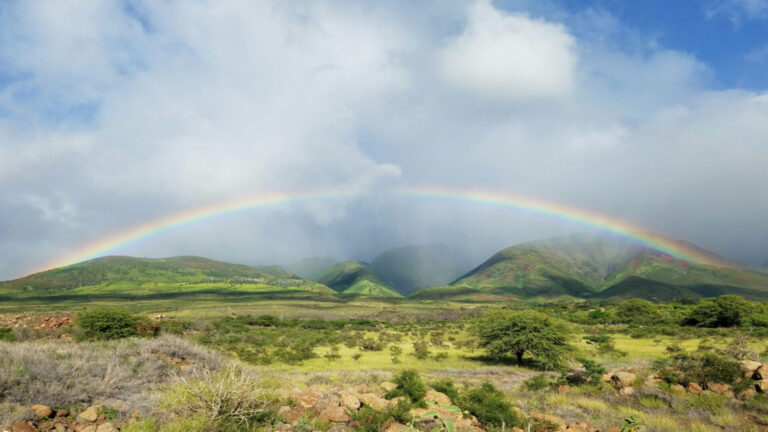 A rainbow arching over the West Maui mountains in Hawaii